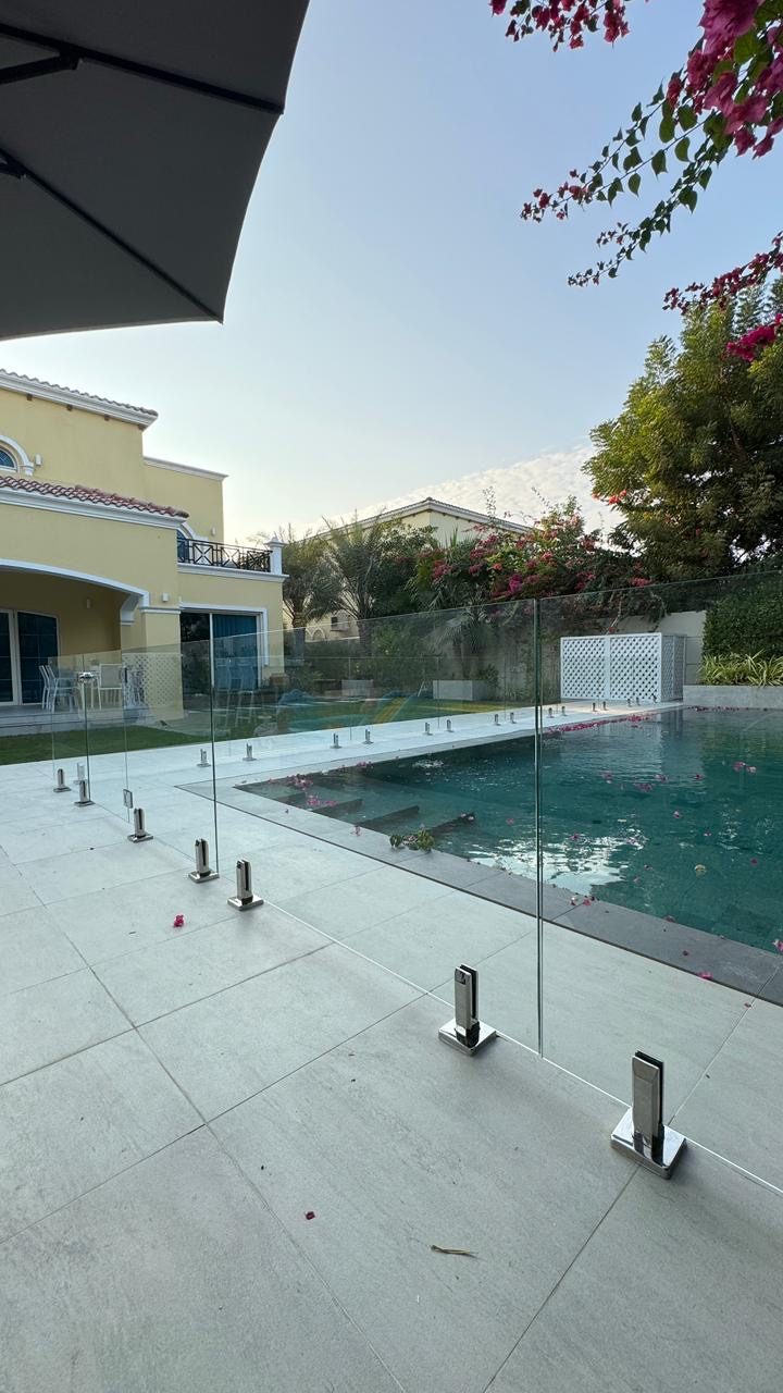 Frameless glass pool fencing with stainless-steel spigots at a Dubai villa